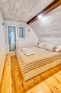 ein Schlafzimmer mit einem großen Bett in einem Zimmer in der Unterkunft Kuća za odmor Miracool in Generalski Stol