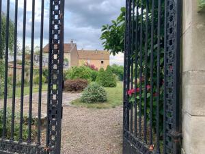 Una puerta de hierro negro con un jardín detrás. en Le Rosier, en Lure