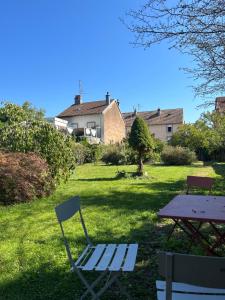 a chair and a picnic table in a yard at Le Rosier in Lure