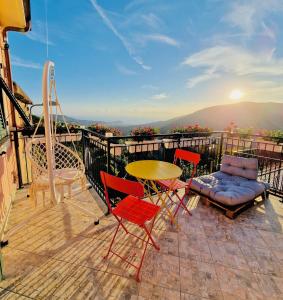un patio con tavolo e sedie su un balcone di La Collina sul Mare - Casa Vacanze a Sestri Levante