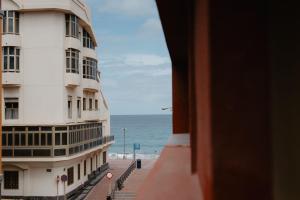 een gebouw naast een strand met de oceaan bij Las Canteras Beach Suites in Las Palmas de Gran Canaria