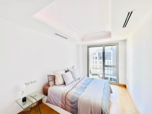 Habitación blanca con cama y ventana en Elegancia y modernidad zona premium Conde de Orgaz Ifema, en Madrid