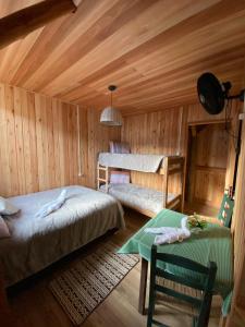 a bedroom with two beds and a table in it at Casarão Biazolli in Farroupilha