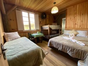 a bedroom with two beds and a chair and a piano at Casarão Biazolli in Farroupilha