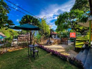 埃拉Mad monkey hostel and lounge的院子里的桌子和雨伞
