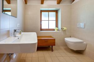 a white bathroom with a sink and a toilet at Urthalerhof Apt Landhaus in Valdaora