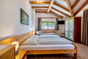 a bedroom with two beds in a room with wooden ceilings at Urthalerhof Apt Landhaus in Valdaora