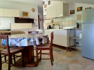 cocina con mesa, sillas y nevera en Il Giardino delle Rose A, en Olmedo