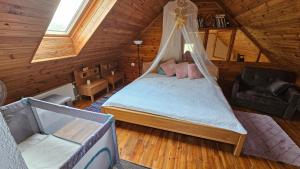 ein Schlafzimmer mit einem Bett in einer Holzhütte in der Unterkunft Burziņi in Kuldīga