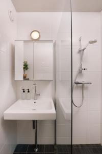 a white bathroom with a sink and a shower at Cozy DAF apartment in Eindhoven