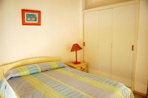 ein Schlafzimmer mit einem Bett und einer Lampe auf einem Nachttisch in der Unterkunft Relax in Mauritius - Private villa with family & friends! - by feelluxuryholiday in Grand-Gaube