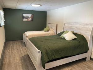 1 dormitorio con 2 camas y pared verde en Private Villa in Pocono Mountains, en Sybertsville