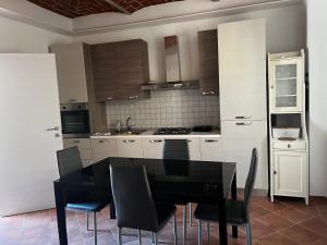 - une cuisine avec une table à manger et des chaises noires dans l'établissement Il BORGHETTO-1, à Grazzano Badoglio