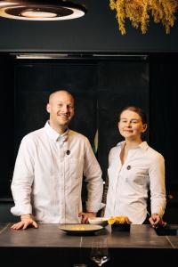 un homme et une femme debout à côté d'une table avec une assiette de nourriture dans l'établissement Roxburgh House Apartments, à Hobart