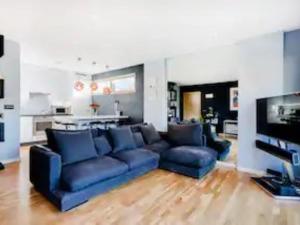 uma sala de estar com um sofá azul e uma televisão em Pass the Keys Boutique London Flat near Tower Bridge and Tube em Londres