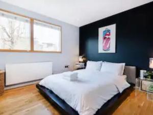 um quarto com uma grande cama branca e uma parede preta em Pass the Keys Boutique London Flat near Tower Bridge and Tube em Londres