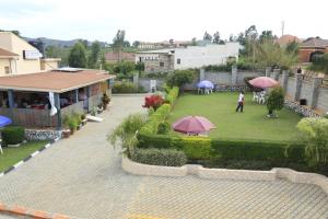 - une vue sur le jardin avec des personnes debout sur une pelouse dans l'établissement Jatheo Hotel Rwentondo, à Mbarara