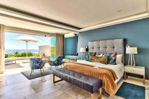 a bedroom with a king sized bed and a view of the ocean at Ocean View House in Cape Town