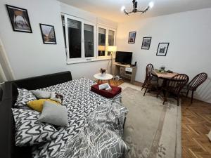 uma sala de estar com uma cama e uma mesa de jantar em Apartman CENTAR em Zenica