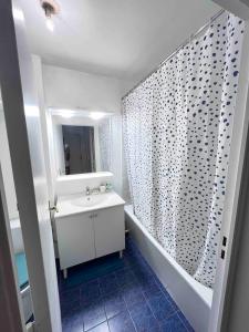 a bathroom with a sink and a shower curtain at 2 pieces - Calme et Lumineux - Parc de La Villette - Stade de France in Aubervilliers