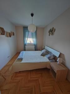 sypialnia z dużym łóżkiem i drewnianą podłogą w obiekcie Krstić_lux apartman w mieście Subotica