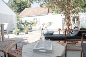 a bottle and glasses on a table on a patio at Casa Palfy in Oslip