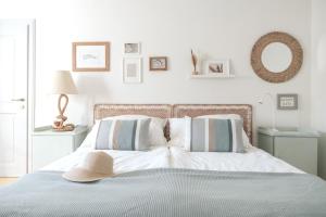 een witte slaapkamer met een bed met een hoed erop bij Casa Palfy in Oslip