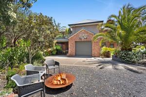 a home with a fire pit in front of a house at Coastal meets Country at this Ventnor Beach Escape in Ventnor