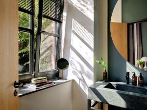 baño con lavabo y ventana en sly Berlin, en Berlín