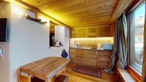 cocina con armarios de madera y mesa de madera en Abitaziun Güglia - Silvaplana, en Silvaplana
