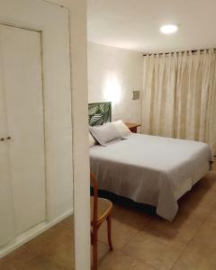 niewielka sypialnia z łóżkiem i krzesłem w obiekcie Hotel Medina B&B w mieście Mar del Plata