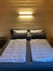two beds in a room with a wooden wall at Ferienhaus Vogelnest in Marktschorgast