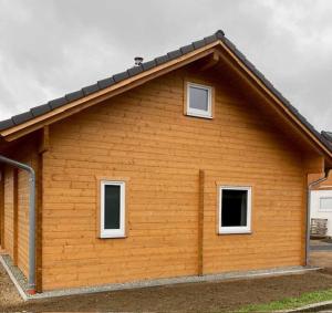 Una casa con dos ventanas en el lateral. en Ferienhaus Vogelnest, en Marktschorgast