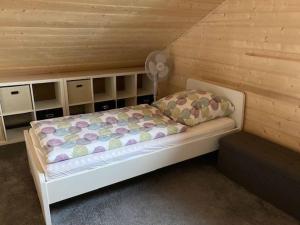 a bed in a room with a wooden wall at Ferienhaus Vogelnest in Marktschorgast