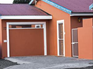 a orange house with a garage at River Olive Estate Accommodation in Beaufort West
