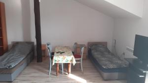ein kleines Zimmer mit einem Tisch und einem Bett in der Unterkunft Tanie noclegi w Bedlnie k. Kutna 