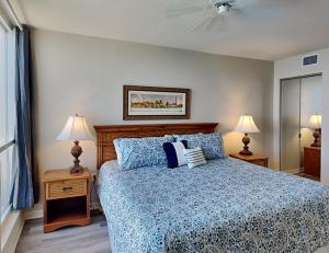 a bedroom with a bed with a blue comforter and two lamps at Lovers Key Resort 1105 - 1 Bedroom - Sleeps 4 in Fort Myers Beach