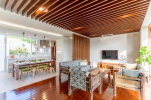 uma sala de estar com mesa e cadeiras e uma sala de jantar em Comfort Villa YAGAJI em Nago