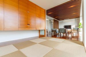 uma cozinha com armários de madeira e uma sala de jantar em Comfort Villa YAGAJI em Nago