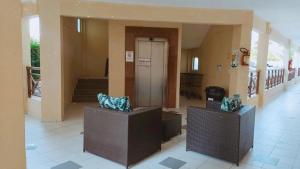 a lobby with two chairs in a building at Apto Completo - Vila do Mar - Beach Park - PDD in Aquiraz