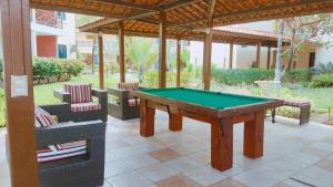 a pool table on a patio with chairs at Apto Completo - Vila do Mar - Beach Park - PDD in Aquiraz