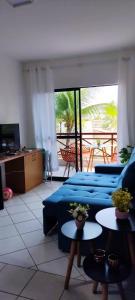 a living room with two blue couches and two tables at Apto Completo - Vila do Mar - Beach Park - PDD in Aquiraz