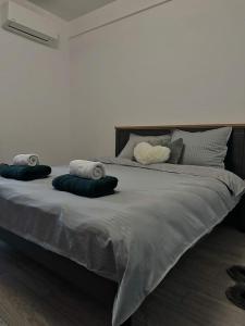 ein großes Bett mit drei Kissen darüber in der Unterkunft Divine Comfort Apartments Palas Mall in Iaşi