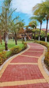 a brick walkway in a park with palm trees at Apto Completo - Vila do Mar - Beach Park - PDD in Aquiraz