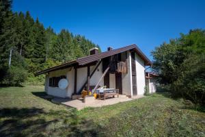 ein kleines Haus mit einem Picknicktisch auf einem Feld in der Unterkunft Svjetlost in Jahorina