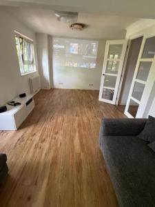 a living room with a couch and wooden floors at Unterkunft für Familien und Gruppen in Seenähe mit Garten in Hannover