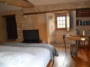 Dormitorio con cama, escritorio y TV en Gîte Beaulieu-sur-Sonnette, 2 pièces, 2 personnes - FR-1-653-219, en Beaulieu-sur-Sonnette