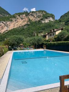 a large blue swimming pool with a mountain in the background at Residence Cascata Varone in Riva del Garda