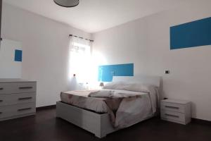 1 dormitorio blanco con 1 cama y vestidor en Casa la Gardenia, en SantʼOreste