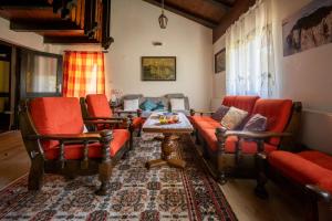 ein Wohnzimmer mit roten Stühlen und einem Sofa in der Unterkunft Svjetlost in Jahorina